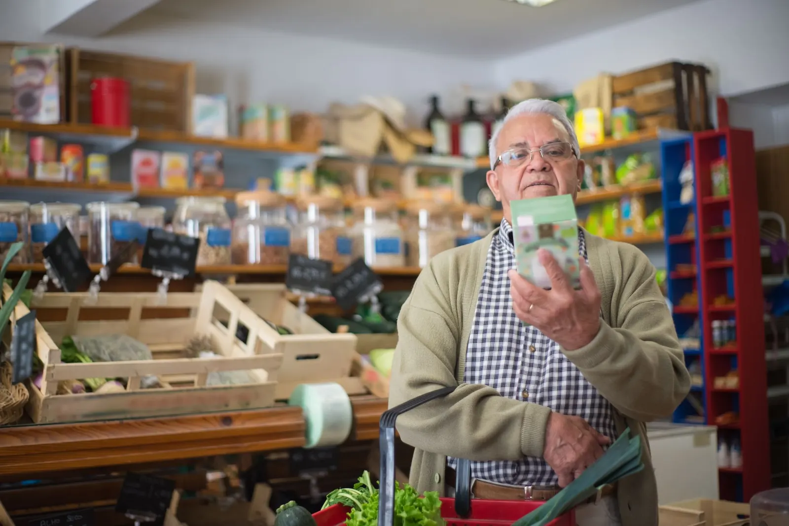 Homem lendo as informações de um produto num mercado de bairro