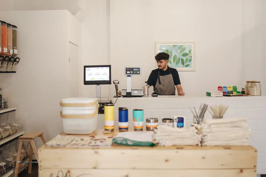 Atendente atrás do balcão de uma loja de produtos a granel