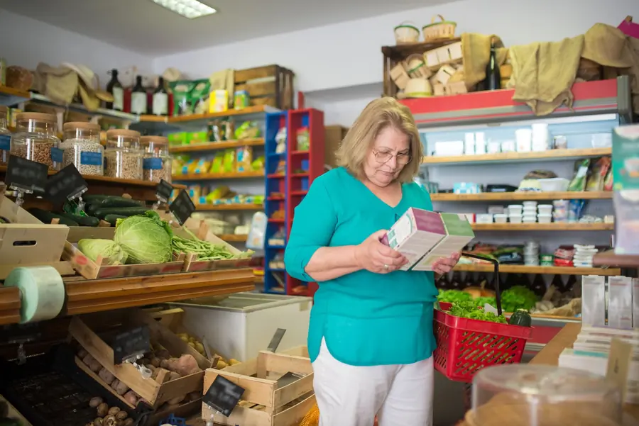 Mulher lendo a lateral de uma caixa de produto numa mercearia