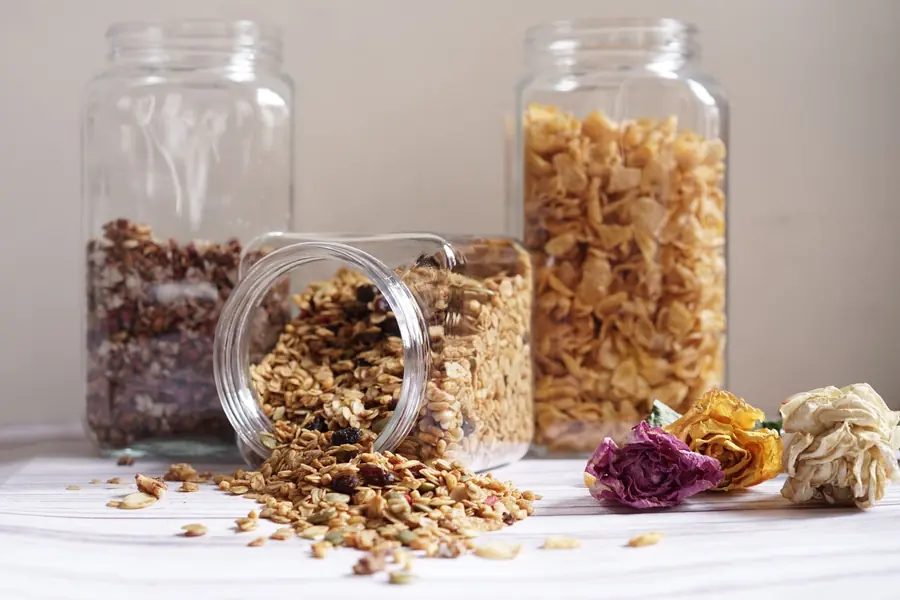Vidros com granola e cereais sobre uma bancada clara